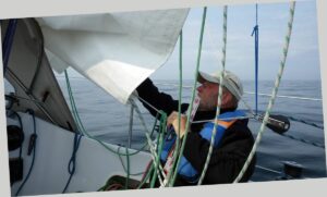 Segel bergen während das Boot im alten Seegang schaukelt