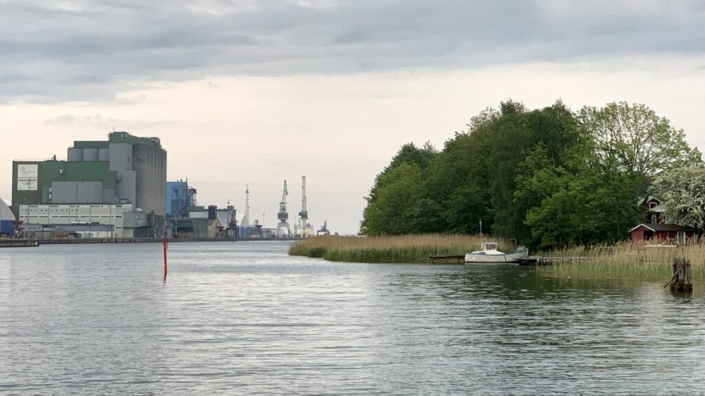 Das Industriegebiet an der Nordseite der Hafeneinfahrt von Åhus und gegenüber auf der Südseite das Naturschutzgebiet