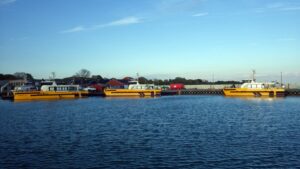 Drei leuchtend gelbe Boote für das Wartungspersonal der Windkraftanlagen im Hafen von Klintholm.