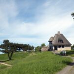 Oben auf dem Hochufer steht das Haus von Knud Rasmussen. Es ist im englischen Cottagestil erbaut und unterscheidet sich sehr deutlich von allen anderen Bauten dort.