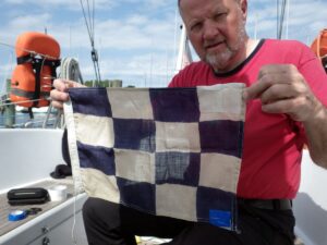 Die Flagge N nehmen wir im Hafen gleich wieder runter. Mit zwei Flicken verstärkt lebt sie hoffentlich noch ein wenig länger.