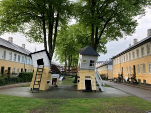 Spielplatz in Brumleby. Die Häuser waren ursprünglich weiß gekalkt. In den 30er Jahren wurden sie gelb gekalkt. Nun sind sie unten gelb und oben weiß. Mich erinnert das an Welfenspeise.
