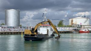 Vor dem Kalkbraenneriehavn wird nicht ausgebaggert, sondern Schlamm abgeladen. Vermutlich ist dies Aushub von der Tunnelbaustelle, der hier nun dem Schutz des Hafens vor Seegang dienen sollen.