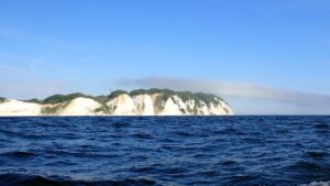 Eine langgestreckte Wolke zieht von den Klippen hinaus auf die See